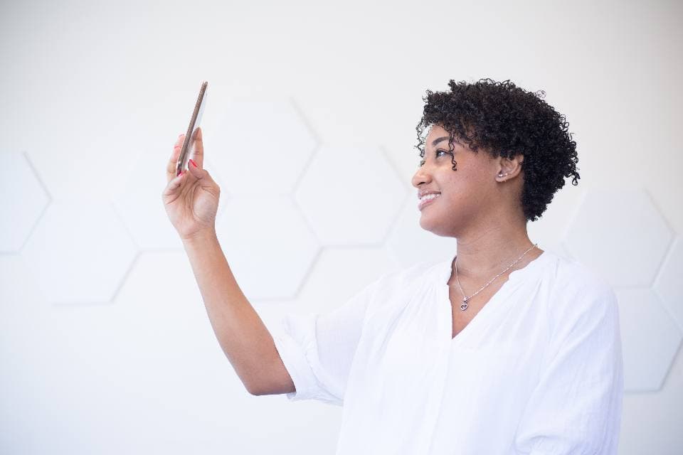A woman looking at her phone and smiling.